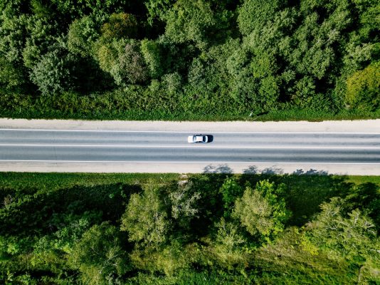 envato aerial-view-of-road-with-car-going-through-green-f-SQKV3Z9 (1)