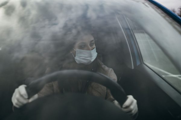 young-woman-in-a-mask-and-gloves-driving-a-car-QPK43R2