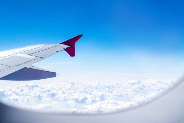 Close up Airplane window with airplane wing ,Traveling concept